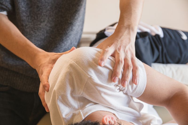 Hands-on shoulder manual therapy on treatment table